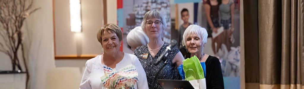 Alice Maitland (left) and Jo Ann Livingston (right) accept Volunteer of the Year award from Laura Pauli (center).